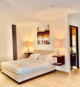 邦劳阿罗那北国度假酒店 的卧室配有一张白色大床和两盏灯。