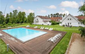 勒维Cozy Apartment In Nykbing Sj With Outdoor Swimming Pool的游泳池的形象,游泳池的椅子和房子