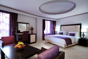 马拉喀什蓝色海洋春日酒店的大型酒店客房设有一张床铺和一张桌子。