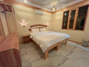 希曼杜岛Black Pearl Himandhoo的一间卧室配有一张带木制床头板的床
