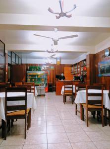 普卡尔帕Hotel Virrey Pucallpa EIRL的餐厅设有桌椅,厨师为背景