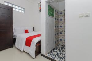 任抹RedDoorz Syariah near Universitas Jember的一间带一张床和淋浴的小卧室