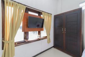 任抹RedDoorz Syariah near Universitas Jember的客房设有电视和窗户。