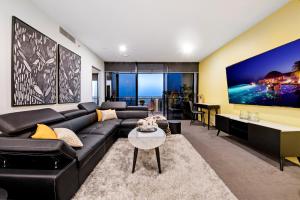 黄金海岸Circle on Cavill - Self Contained, Privately Managed Apartments的客厅配有黑色沙发和桌子