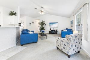 佩尔迪多海滩Charming Pensacola House with All Needed Essentials的客厅配有2把蓝色椅子和吊扇