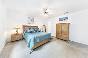 佩尔迪多海滩Charming Pensacola House with All Needed Essentials的一间卧室配有一张床、梳妆台和吊扇