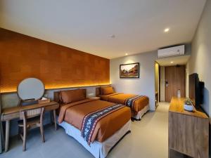 纳闽巴霍Parlezo by Kagum Hotels的酒店客房配有两张床和一张书桌