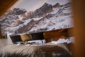 英格堡VILLA HUNDERT Boutique Mountainscape的卧室的天花板上装饰有雪覆盖的山壁画