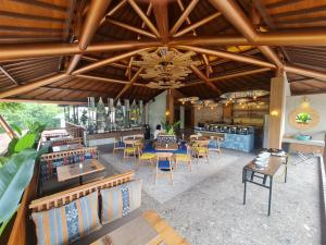 纳闽巴霍Parlezo by Kagum Hotels的餐厅设有木制天花板和桌椅