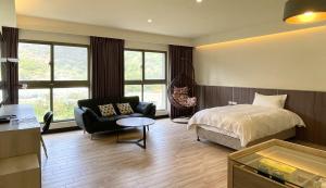 北竿龙福山庄的一间卧室配有一张床、一把椅子和一张桌子