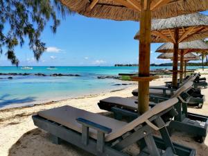 蒙舒瓦西Wonders Beach Boutique Hotel的海滩上一排沙滩椅和遮阳伞