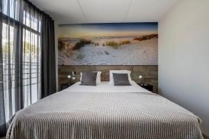 诺德韦克Holiday Apartment Strand的卧室配有一张大床,墙上挂有绘画作品