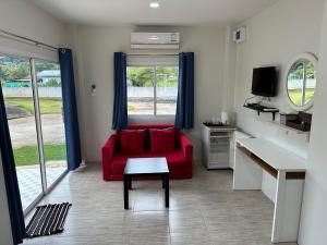 慕斯Plearn Khaoyai Resort的客厅配有红色沙发和电视