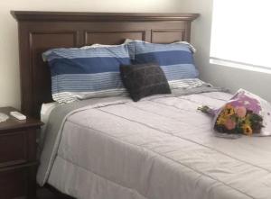 DonoeLeona's Hidden Adventure home的一张带两个枕头的床和一束鲜花