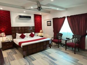 拉合尔Lawrence View Hotel Lahore的酒店客房带一张床、一张桌子和椅子