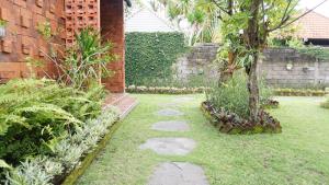 沙努尔Louto Dmell Guesthouse的一座带石头走道和树的花园