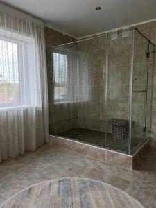 库斯塔奈Grand SPA Hotel的带淋浴的浴室和玻璃墙