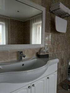 库斯塔奈Grand SPA Hotel的一间带水槽和大镜子的浴室
