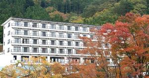 那须盐原市Nasushiobara Ichimantei的山前有树木的白色建筑