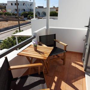 安迪帕罗斯岛Villa Del Mar的阳台配有一张木桌和一把椅子