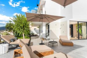 阿德耶Avitan Premium & Luxury Villas的别墅享有带遮阳伞的庭院景致