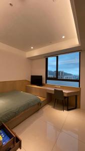 新庄J-Double Room Xinzhuang District的一间卧室配有书桌、床和窗户。