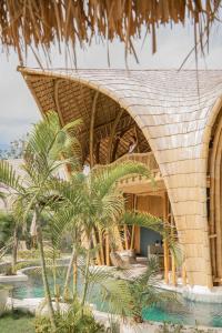 吉利阿尔Villa Tokay - Luxury Private Villas的草屋顶和棕榈树度假村