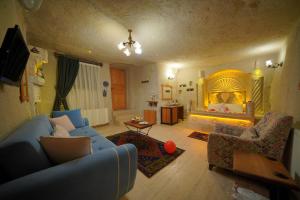 奥塔希萨尔化石洞酒店的客厅配有蓝色的沙发和床。