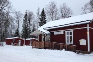 ÅshammarVLS Stugby的屋顶上白雪的红色小屋