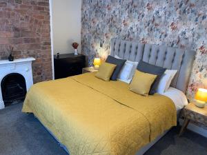 艾纯查姆46 Ashfield Rd, Altrincham的卧室配有一张带黄色床单和枕头的大床。