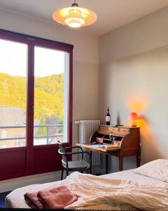Hastière-par-delàVilla Michaux的一间卧室配有一张床、一张书桌和一个窗户。