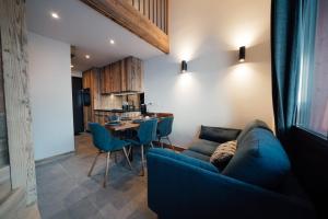蒂涅Studio Interlude by ExplorHome的客厅配有蓝色的沙发和桌子