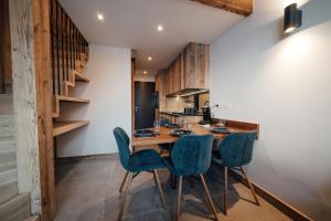 蒂涅Studio Interlude by ExplorHome的厨房配有木桌和蓝色椅子