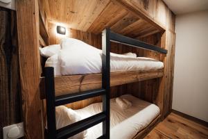 蒂涅Studio Interlude by ExplorHome的木墙客房的两张双层床