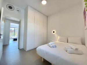 特拉维夫12 Shimon HaTzadik - By Beach Apartments TLV的白色卧室配有一张大床和毛巾