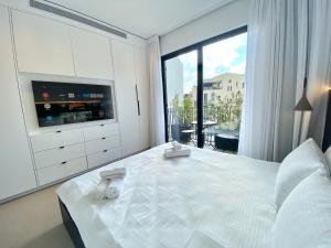 特拉维夫12 Shimon HaTzadik - By Beach Apartments TLV的卧室设有一张白色大床和大窗户