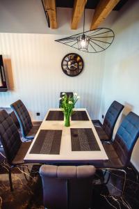乌斯特龙Apartament LUX Ustroń的一间带桌椅和时钟的用餐室