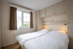 Biggekerke斯特朗营地瓦尔肯斯酒店的一间卧室设有两张白色的床和窗户