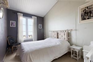 圣马丹德雷Appartement Neptune的卧室配有白色的床和窗户。