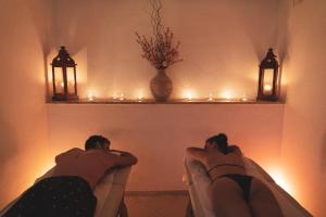 孔图尔西泰尔梅罗莎佩佩酒店的两个人躺在灯火通明的房间的椅子上