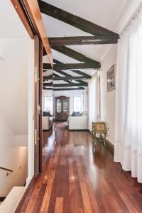 威尼斯San Marco Bell Tower House的大型客厅铺有木地板,设有大窗户