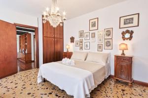 威尼斯San Marco Bell Tower House的卧室配有一张白色大床和吊灯。