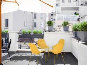 罗马numa I Vici Rooms & Apartments的阳台的天井配有黄色椅子和桌子