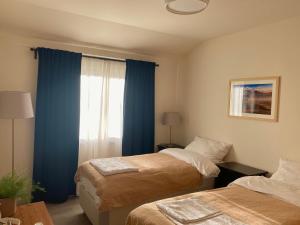 夫洛雷恩Dharma City的一间卧室设有两张床,窗户配有蓝色窗帘