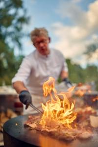SalavauxChâteau Salavaux的火烤架上的男人烹饪食物