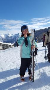拉尔让蒂埃拉贝塞埃Hôtel Restaurant Glaizette的一位妇女站在雪地里,滑雪板上