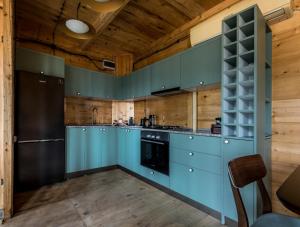K'edaHill Inn的厨房配有蓝色橱柜和黑色冰箱。