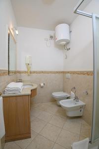 坎普码头伊尔巴玛莉娜迪坎普酒店的浴室设有2个卫生间、水槽和淋浴。