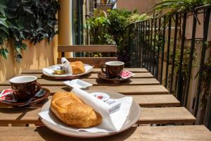 陶尔米纳Badia Holiday Home的一张桌子,上面放着两盘面包和咖啡