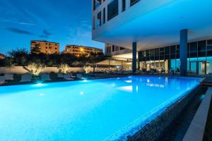 索林索罗那宫酒店的一座游泳池,在晚上在建筑物前